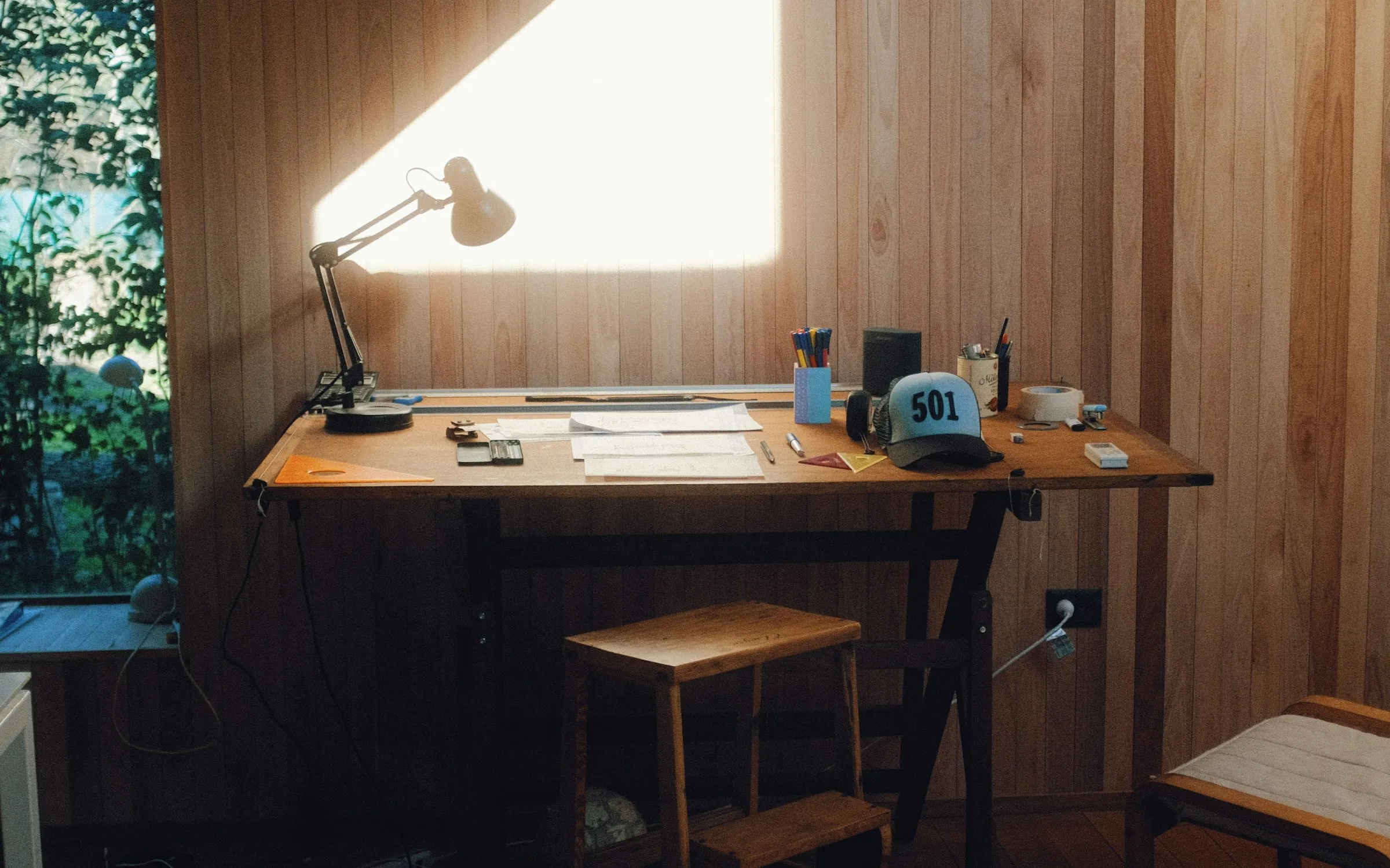 Estudio de madera con un escritorio de trabajo bañado por luz cálida de tarde.